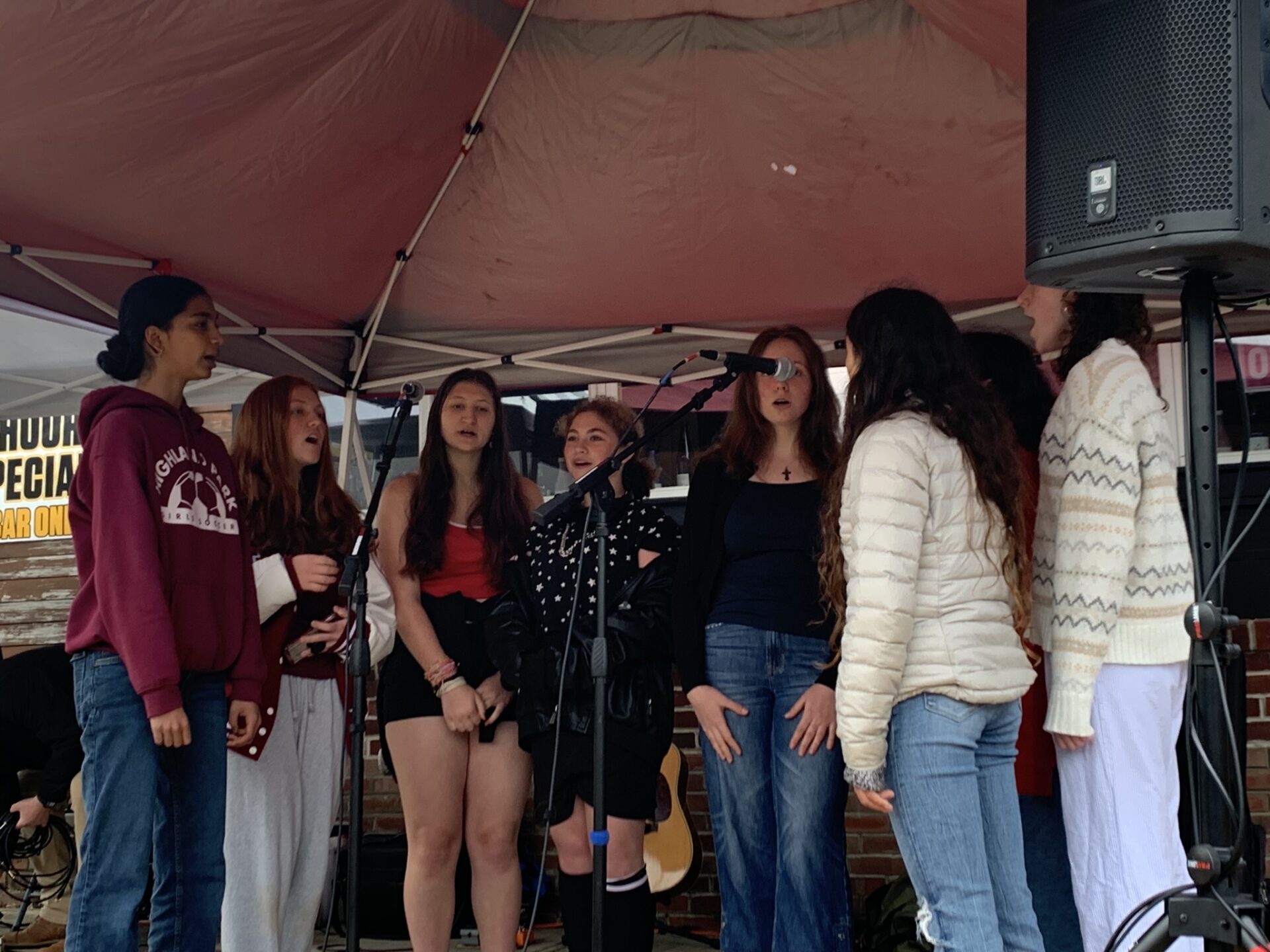 A group of girls performing under a canopy.